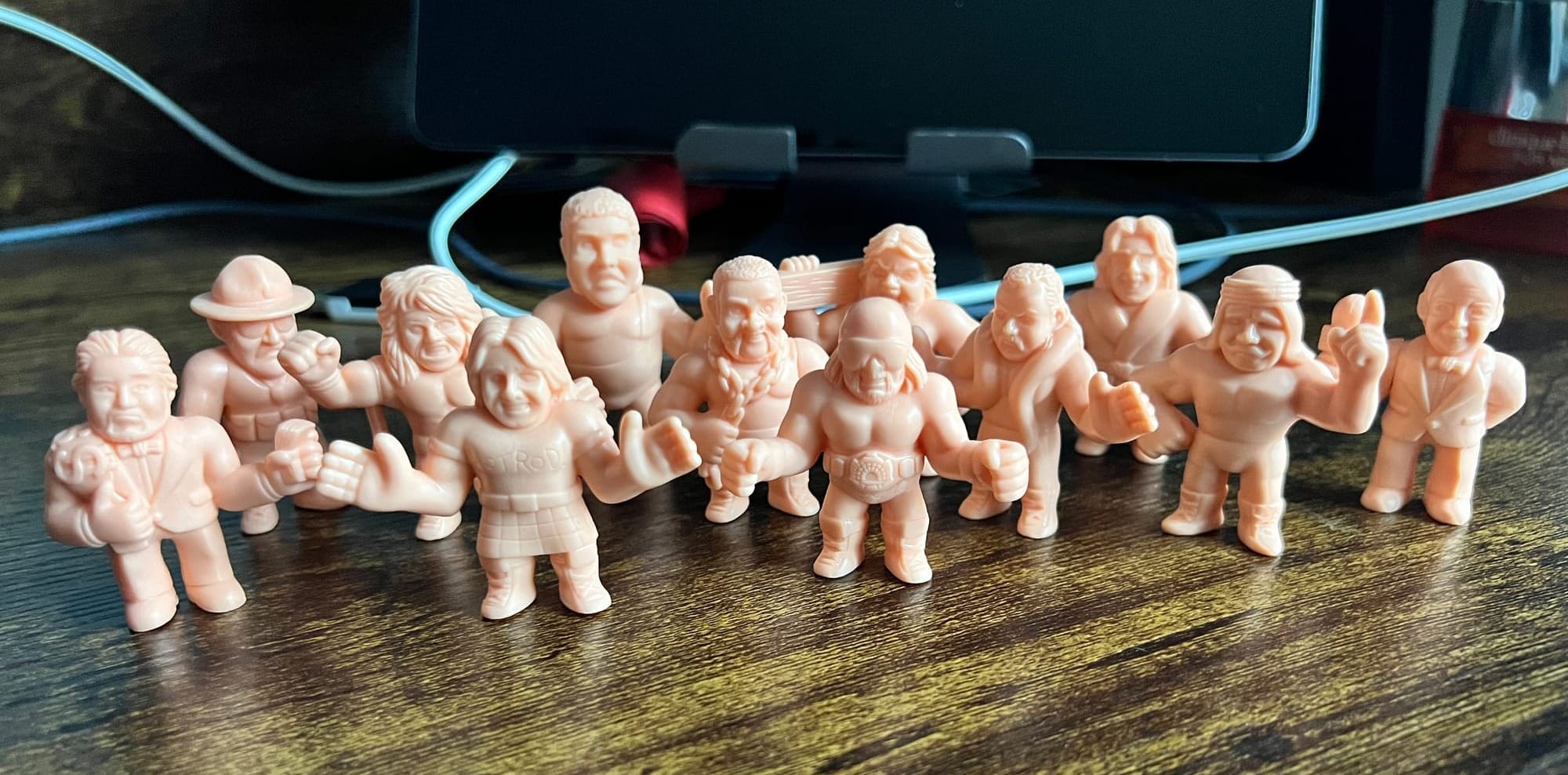 all 12 M.U.S.C.L.E. WWE figures are positioned, as if standing in a group on 